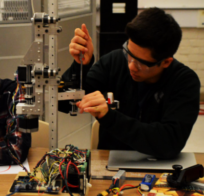 A student working on a robot arm built by Google and MVRT students